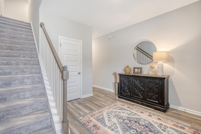 stairway featuring wood finished floors and baseboards