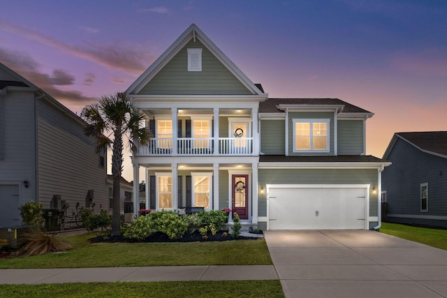 view of front of house featuring a yard, a balcony, and a garage