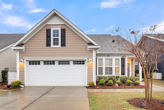 traditional-style home featuring driveway and roof with shingles