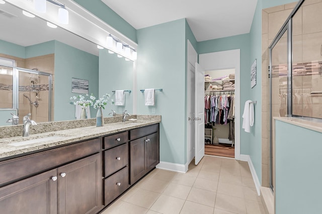 full bathroom with tile patterned floors, visible vents, a stall shower, a sink, and double vanity