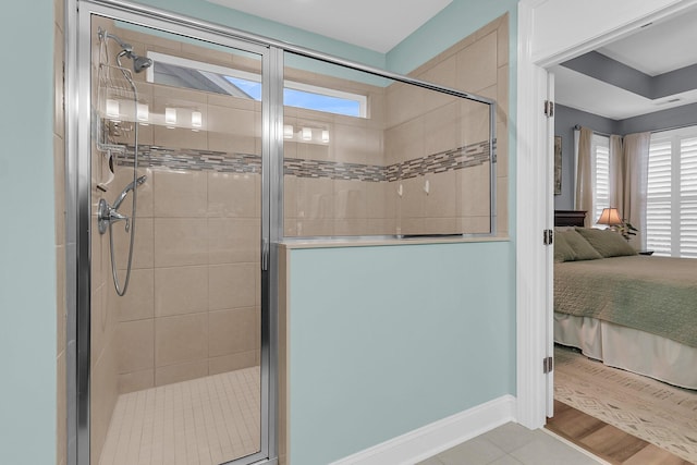 ensuite bathroom with visible vents, connected bathroom, a shower stall, and baseboards