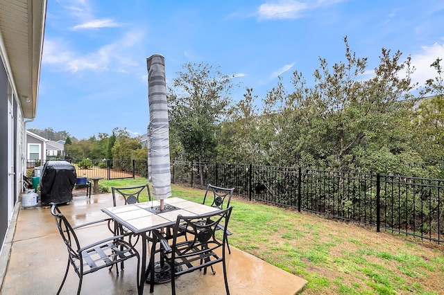 view of patio with area for grilling, outdoor dining area, and a fenced backyard