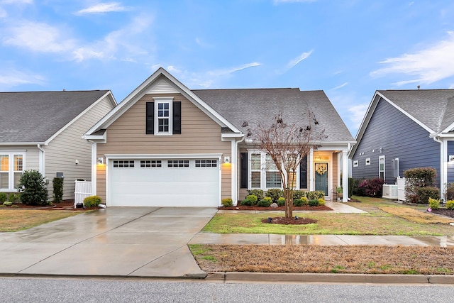 traditional home featuring a garage, a front yard, driveway, and a shingled roof