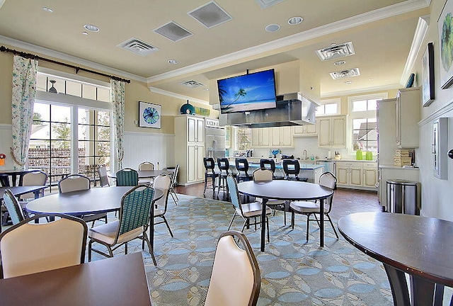 dining room with visible vents, wainscoting, and crown molding