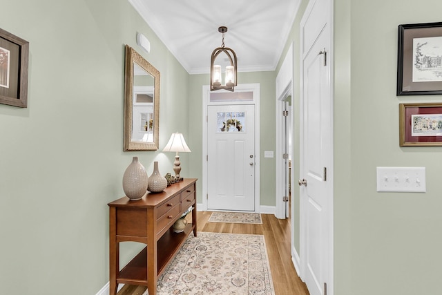 foyer entrance featuring light wood-style flooring, baseboards, and ornamental molding