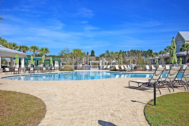 pool with a patio area and fence