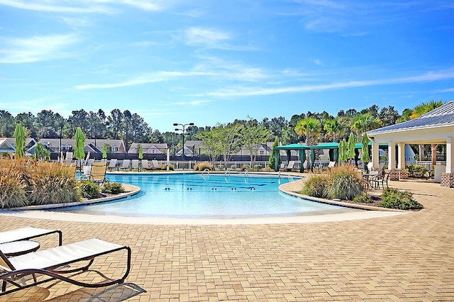 pool with a gazebo, fence, and a patio area