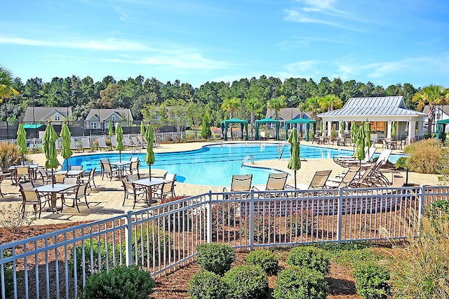 community pool featuring a gazebo, a patio area, and fence