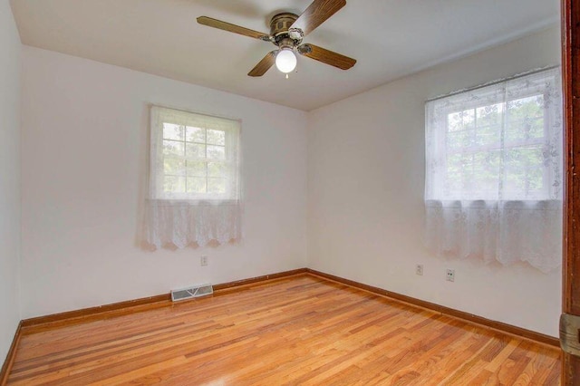 unfurnished room with baseboards, visible vents, ceiling fan, and light wood finished floors