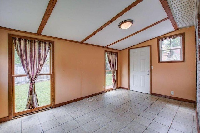 spare room with lofted ceiling with beams, light tile patterned floors, and baseboards