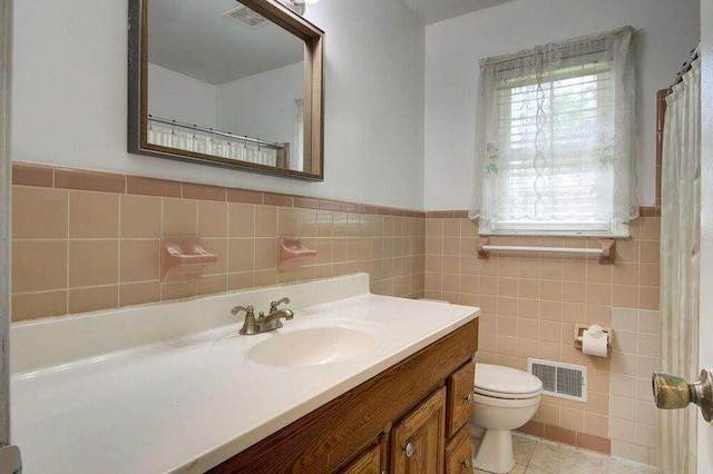 full bathroom featuring visible vents, toilet, tile patterned flooring, vanity, and tile walls