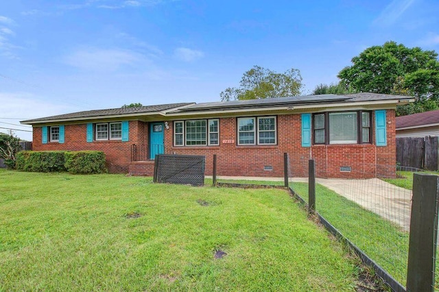 single story home with crawl space, roof mounted solar panels, a front lawn, and brick siding