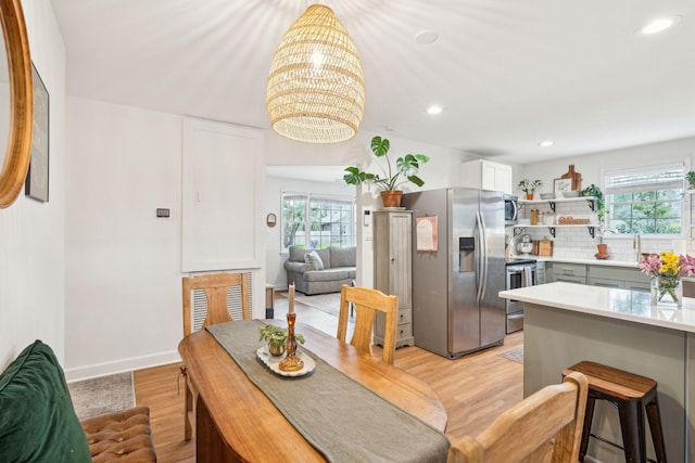 dining area featuring baseboards, a notable chandelier, light wood-style flooring, and recessed lighting