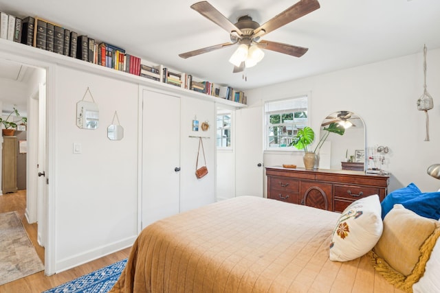 bedroom with light wood-type flooring, a closet, and a ceiling fan