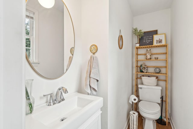 bathroom with vanity, toilet, and baseboards