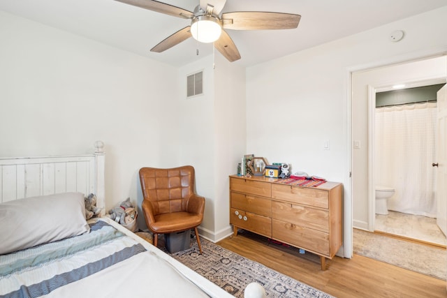 bedroom featuring a ceiling fan, baseboards, visible vents, and wood finished floors