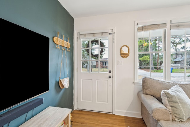 doorway with light wood finished floors and baseboards