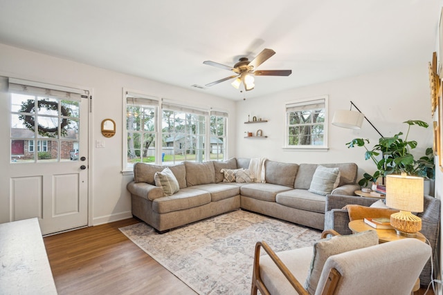 living room with a healthy amount of sunlight, ceiling fan, baseboards, and wood finished floors