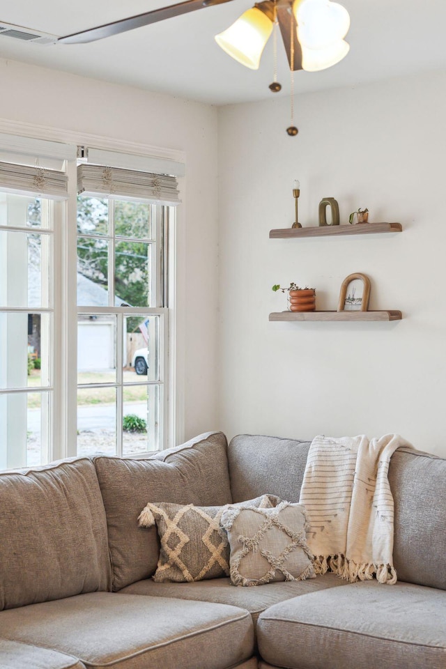 living room with ceiling fan, visible vents, and a healthy amount of sunlight