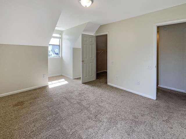 bonus room with vaulted ceiling and carpet