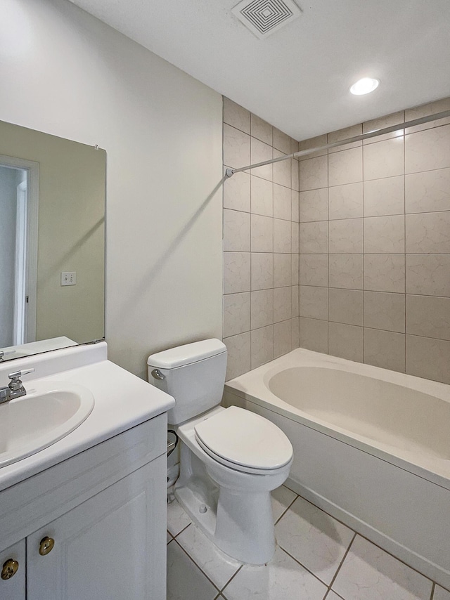 full bathroom with tile patterned flooring, vanity, tiled shower / bath, and toilet