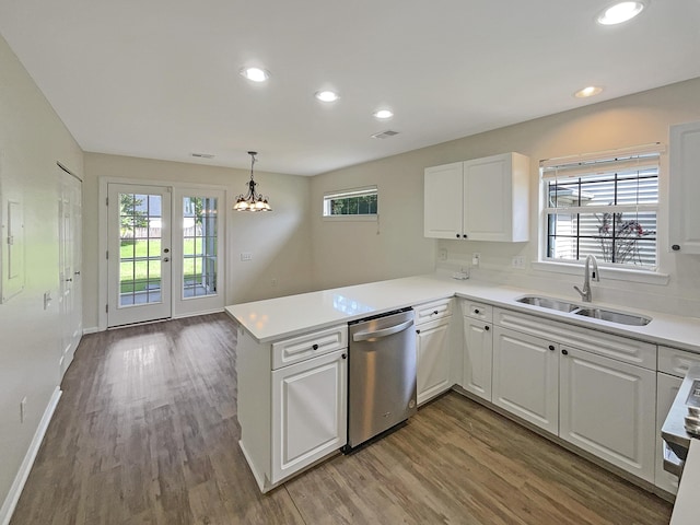 kitchen featuring sink, white cabinets, hanging light fixtures, stainless steel dishwasher, and kitchen peninsula