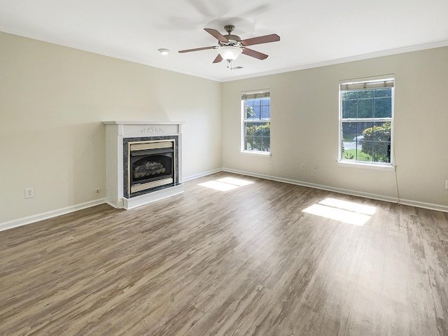 unfurnished living room with hardwood / wood-style flooring, ceiling fan, and ornamental molding