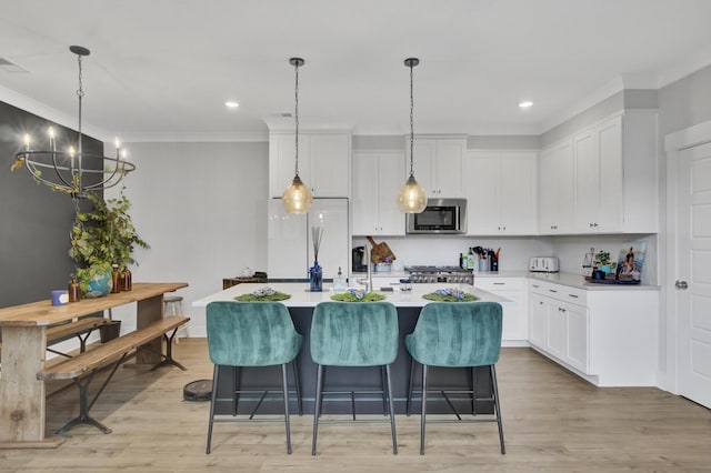 kitchen featuring white cabinetry, backsplash, pendant lighting, and a kitchen island with sink