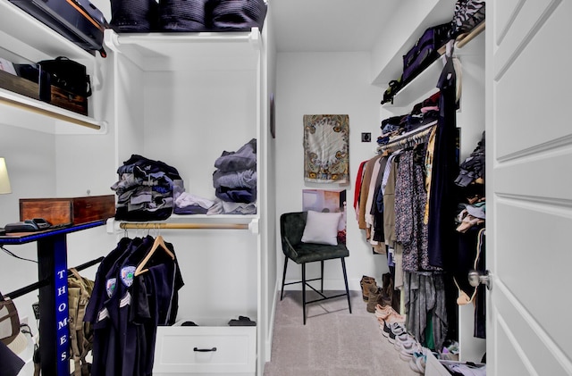 walk in closet featuring light carpet