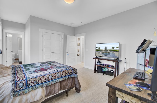 carpeted bedroom featuring ensuite bath