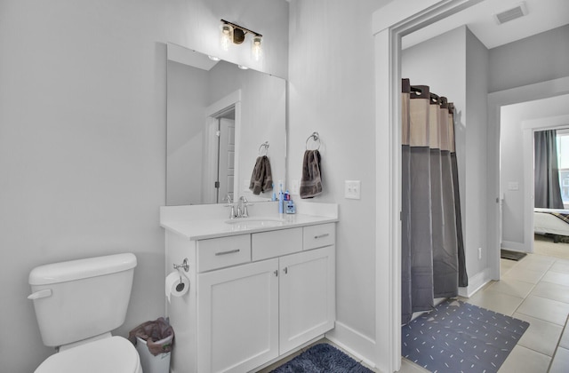 bathroom with vanity, walk in shower, tile patterned floors, and toilet