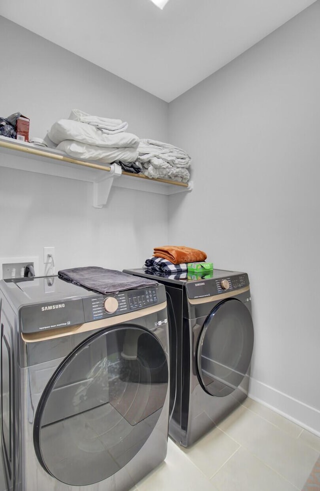 laundry room featuring washer and dryer and light tile patterned floors