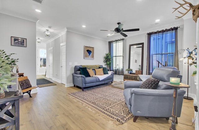 living room featuring crown molding, light hardwood / wood-style flooring, and ceiling fan