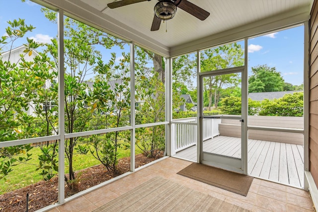 unfurnished sunroom with ceiling fan and a water view
