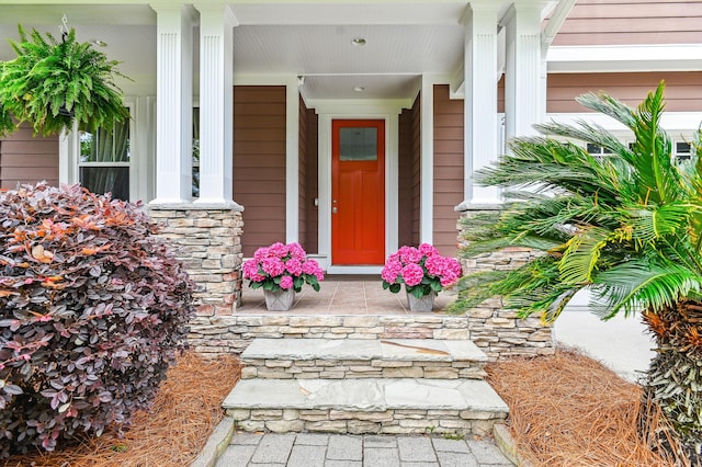 entrance to property with covered porch and stone siding