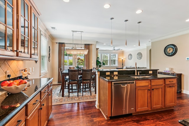 kitchen with stainless steel dishwasher, a sink, brown cabinets, crown molding, and dark stone counters