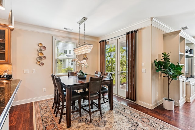 dining room featuring wood finished floors, plenty of natural light, baseboards, and ornamental molding