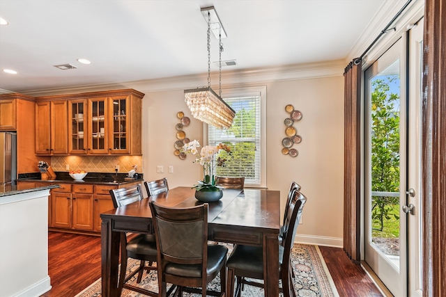dining space featuring dark wood-style flooring, ornamental molding, recessed lighting, baseboards, and a chandelier