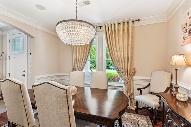 dining room with arched walkways, ornamental molding, a chandelier, a wainscoted wall, and a decorative wall