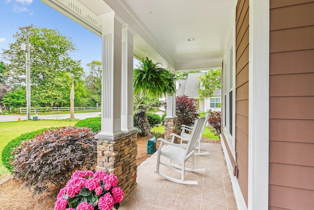 view of patio featuring a porch and fence