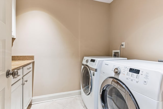 washroom featuring separate washer and dryer, baseboards, and cabinet space