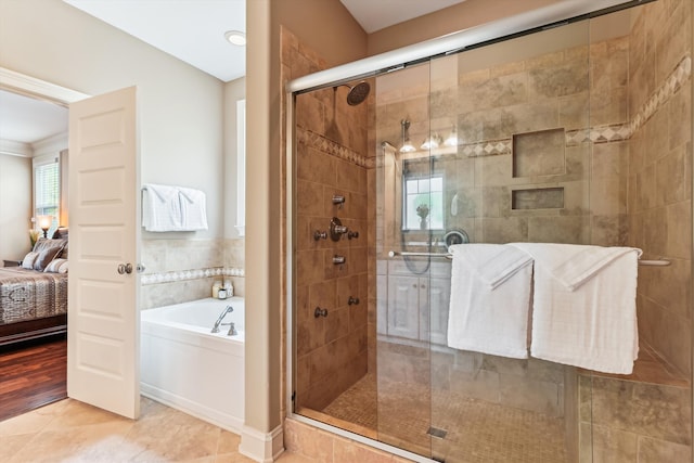 ensuite bathroom with a garden tub, a stall shower, and tile patterned flooring