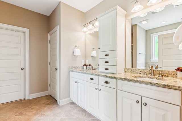 bathroom with double vanity and baseboards