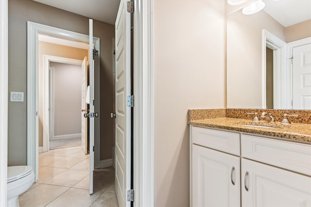 bathroom featuring vanity, tile patterned flooring, toilet, and baseboards
