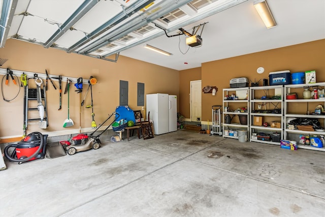 garage featuring electric panel, a garage door opener, and freestanding refrigerator