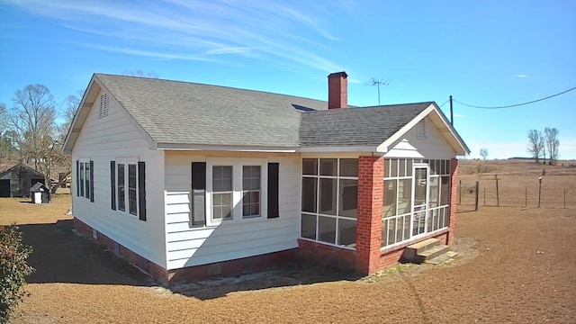 rear view of house featuring a sunroom