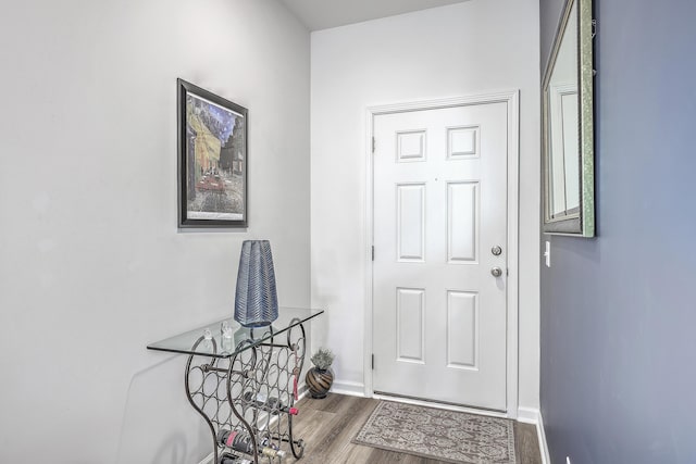 doorway featuring wood finished floors and baseboards