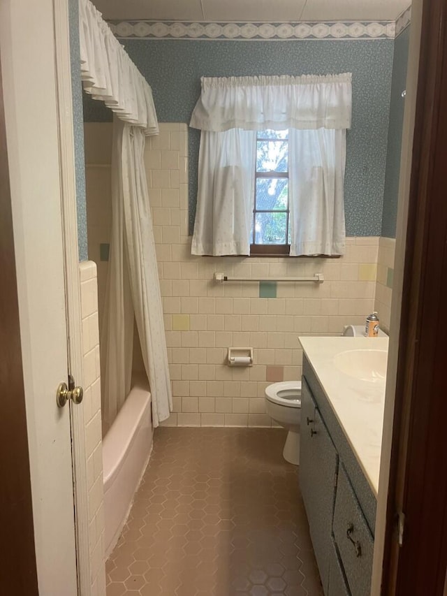 874 Evans Rd, Charleston, SC 29412 - full bath with tile walls, vanity, wallpapered walls, shower / tub combo with curtain, and a wainscoted wall