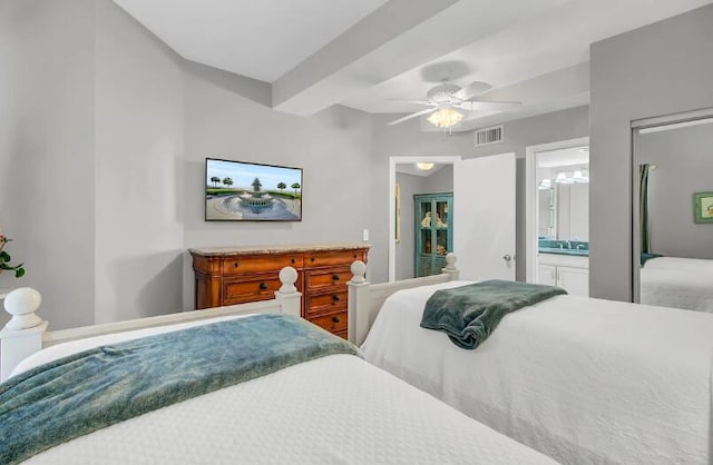 bedroom with beamed ceiling, ceiling fan, and connected bathroom