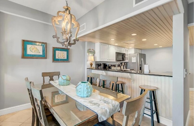 tiled dining area with a chandelier